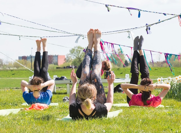 Un grand groupe d'adultes assistant à des cours de yoga dans le parc