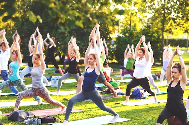 Grand groupe d'adultes assistant à un cours de yoga à l'extérieur dans le parc