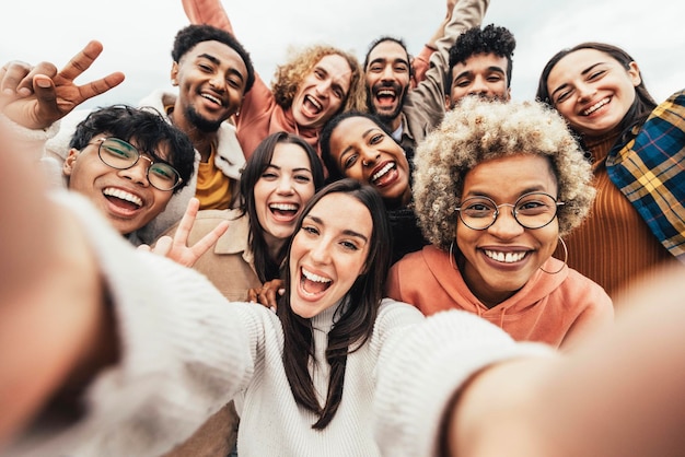 Grand groupe d'amis prenant une photo de selfie souriant à la caméra