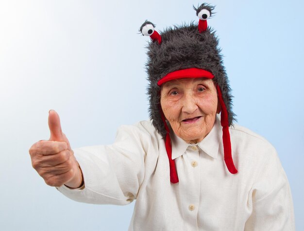 Photo grand-mère au chapeau drôle montre les pouces vers le haut