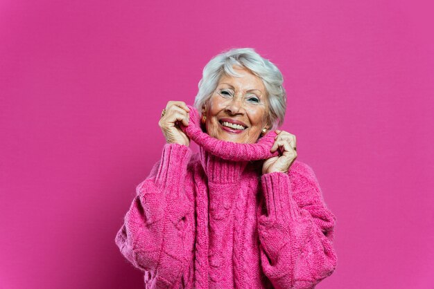 Grand-mère cool posant en studio portant des vêtements à la mode et faisant la fête