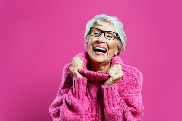 Grand-mère cool posant en studio portant des vêtements à la mode et faisant la fête