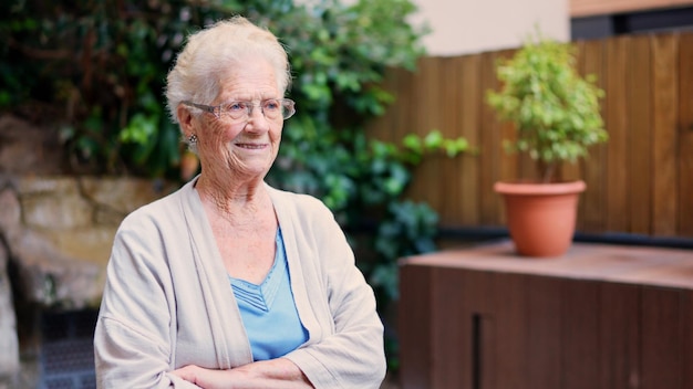 Une grand-mère distraite détournant son regard devant une maison de retraite.