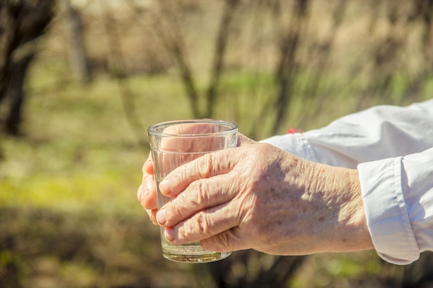 Grand-mère donnant un verre d'eau propre à un enfant Mise au point sélective