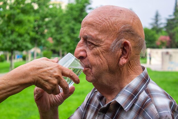 La grand-mère donne de l'eau au grand-père.