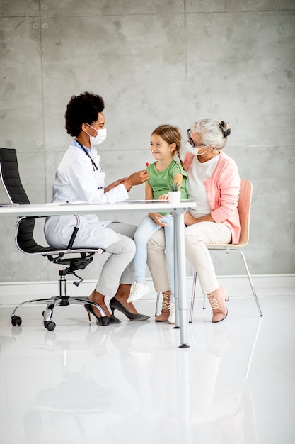 Grand-mère avec jolie petite-fille médecin femme noire au bureau