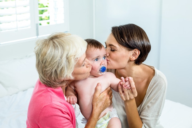 Grand-mère, mère, baisers, bébé, garçon, lit