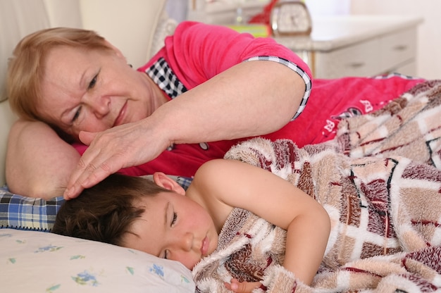 La grand-mère met l'enfant au lit