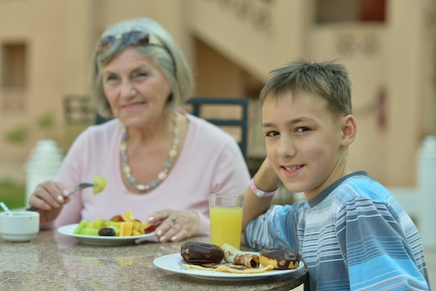 Photo grand-mère avec petit-fils au petit-déjeuner sur la table