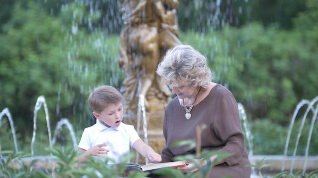 Grand-mère avec petit-fils lisant un livre ensemble