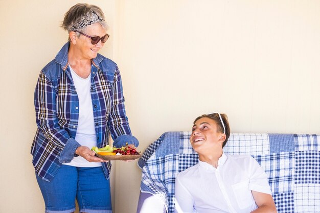 Grand-mère et petit-fils à la maison avec des fruits frais et sains