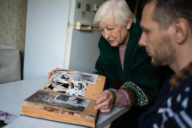 La grand-mère et le petit-fils regardent ensemble un album de photos
