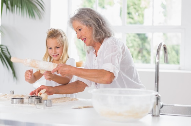 Grand-mère et petite-fille à l&#39;aide d&#39;un rouleau à pâtisserie