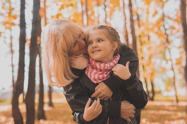Grand-mère avec petite-fille en automne parc génération et concept familial