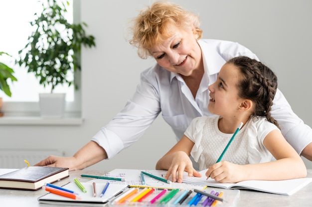 Grand-mère avec petite fille faisant ses devoirs.