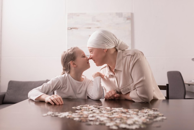 Grand-mère et petite-fille jouant ensemble avec un puzzle, concept de cancer