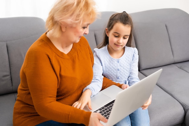 Grand-mère et petite-fille avec ordinateur portable.