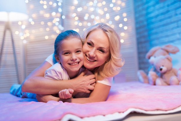 Grand-mère et petite-fille s&#39;embrassent sur le lit