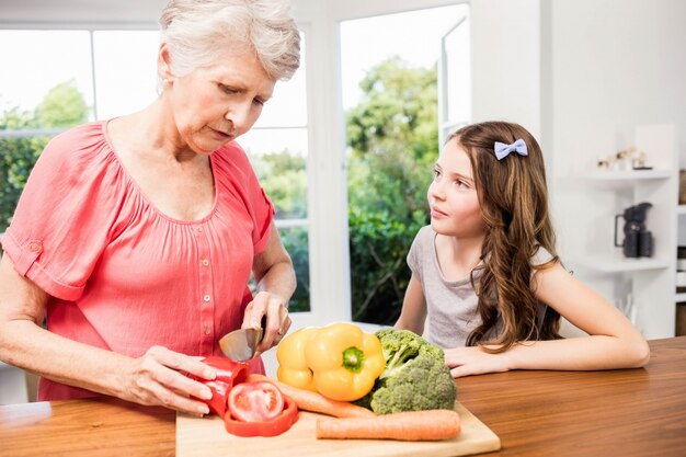 Grand-mère Et Petite-fille Trancher Des Légumes Dans La Cuisine