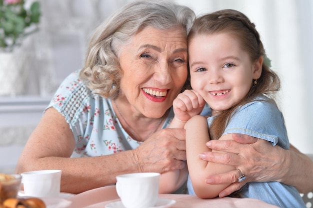 Photo une grand-mère avec une petite petite-fille buvant du thé