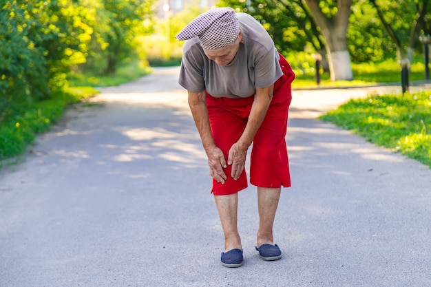 Photo grand-mère se blesse au genou sur la route mise au point sélective