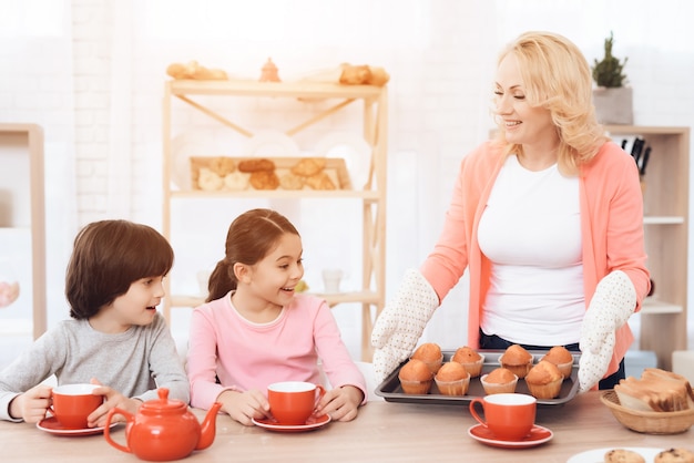 Grand-mère tenez le plateau avec le concept de petit déjeuner de muffins