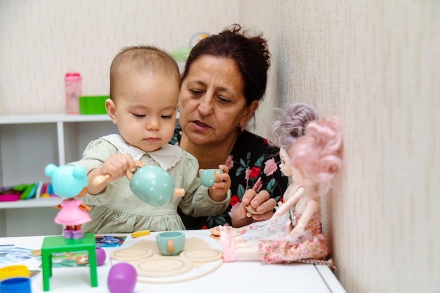 Photo grand-mère et tout-petit jouant avec des jouets à la maison