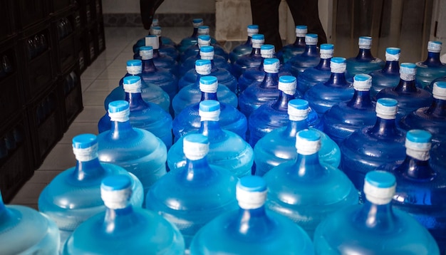 Un grand nombre de gallons bleus en plastique de produits d'eau potable dans une usine d'eau potable