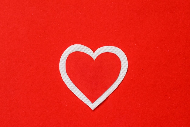 Grand papier coeur rouge et blanc sur fond de papier rouge. concept de la Saint-Valentin