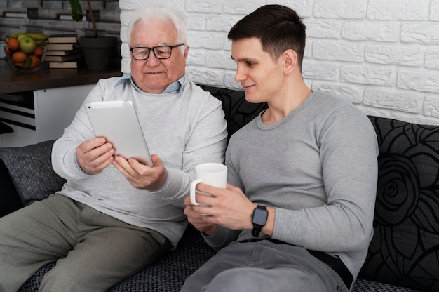 Photo grand-parent apprenant à utiliser un appareil numérique