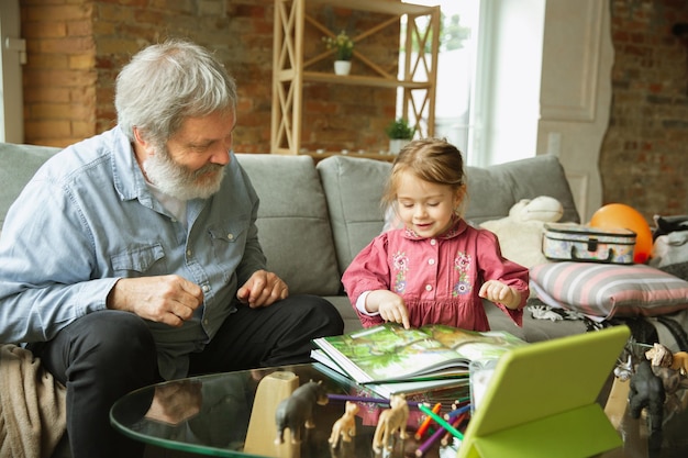 Grand-père et enfant jouant ensemble à la maison. Bonheur, famille, relation, concept d'éducation.