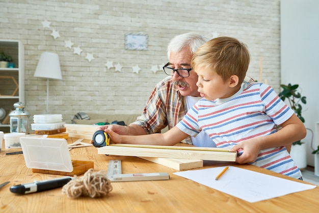 Grand-père enseignant la menuiserie du petit garçon