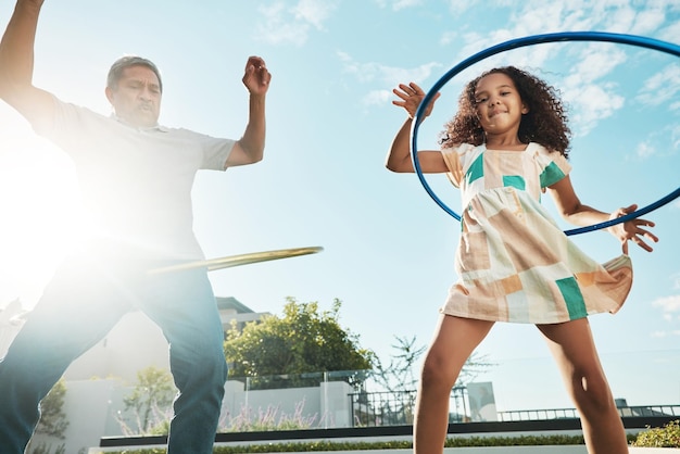 Grand-père fille enfant et famille hula hoop en ville s'amusant et se liant ensemble à l'extérieur