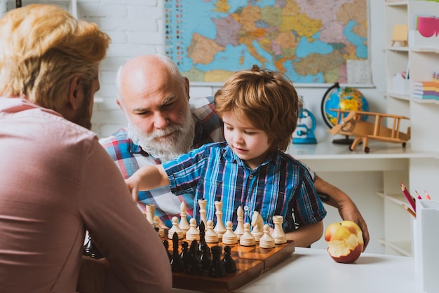 Grand-père père et fils jouant aux échecs hommes heureux générations famille grand-père et mignon petit garçon g