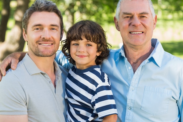 Grand père père et fils souriant au parc