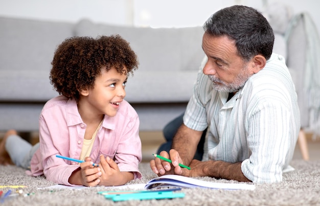 Grand-père et petit-fils dessinent et parlent dans le salon