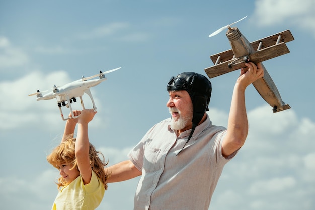 Grand-père et petit-fils avec drone avion et quadcopter sur fond bleu ciel et nuages personnes âgées