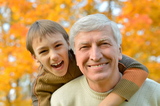 Grand-père et petit-fils ensemble dans le parc d'automne