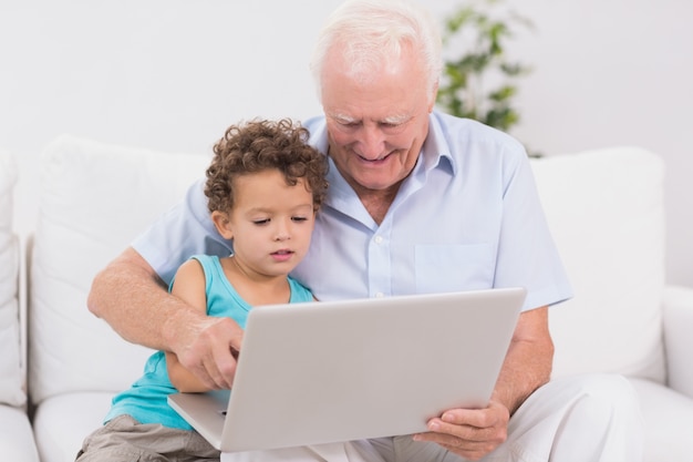 Grand-père et petit-fils en regardant un écran d&#39;ordinateur portable