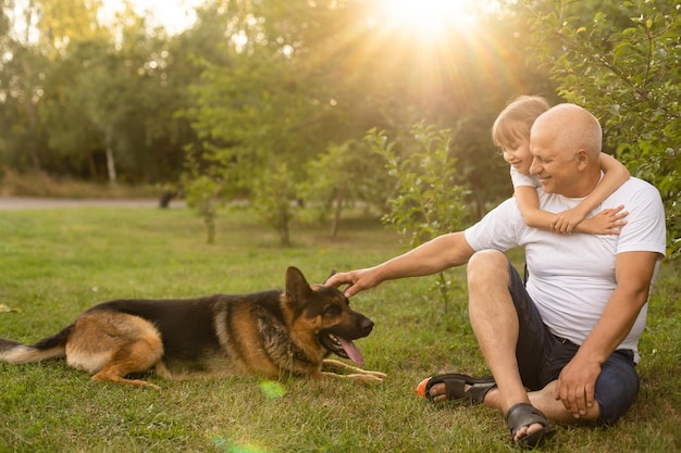 Grand-père avec petite-fille et un chien dans le jardin