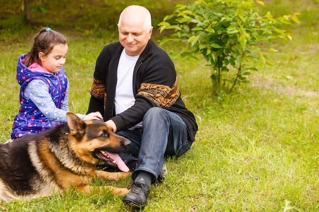 Grand-père et petite-fille prenant le chien pour la promenade