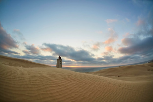 Grand phare sur de grandes dunes de sable