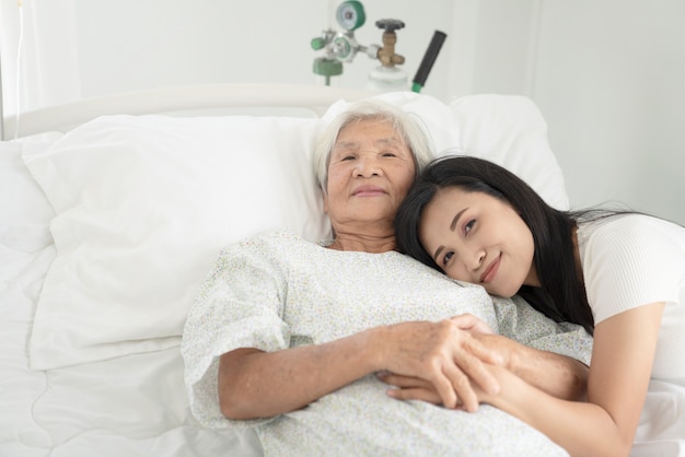 Grand plan, de, patient, grand-père, et, femmes, tenant mains, dans lit hôpital