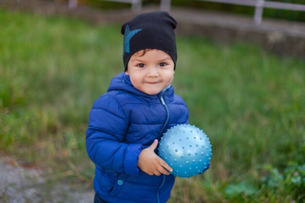 Grand portrait d&#39;un enfant dans la rue avec un ballon.