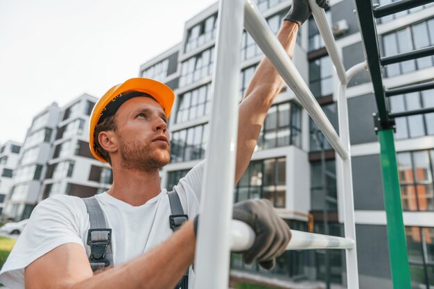 Grand projet Jeune homme travaillant en uniforme à la construction pendant la journée