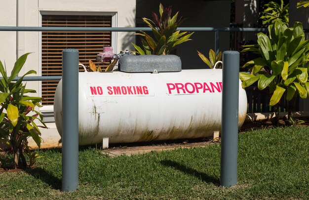 Grand réservoir de propane dans jardin paysagé