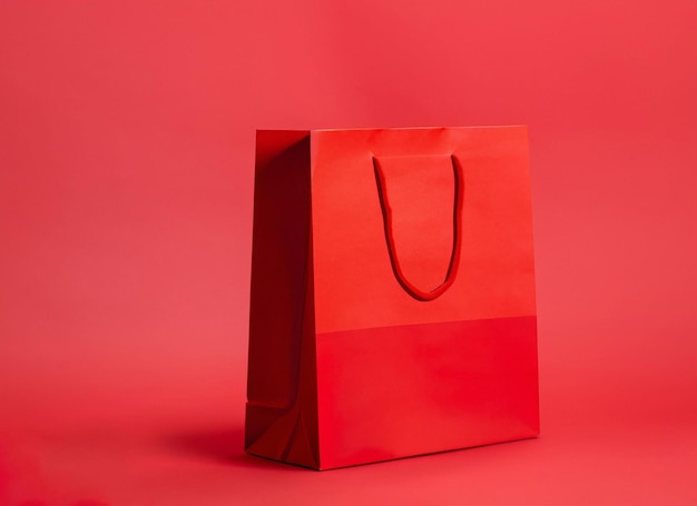 Grand sac en papier shopping rouge sur fond rouge Maquette