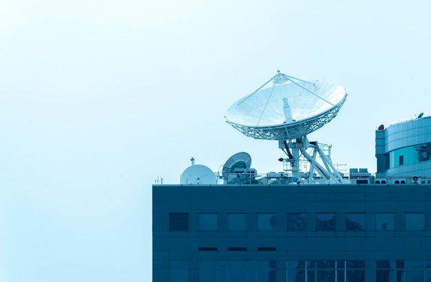 Grande antenne parabolique sur le toit du bâtiment