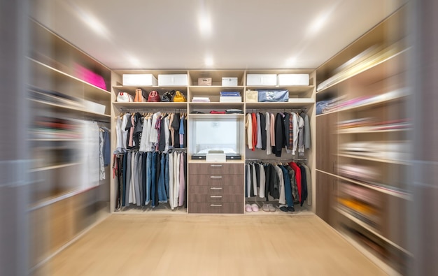 Grande armoire avec différents vêtements pour dressing avec effet de flou de mouvement