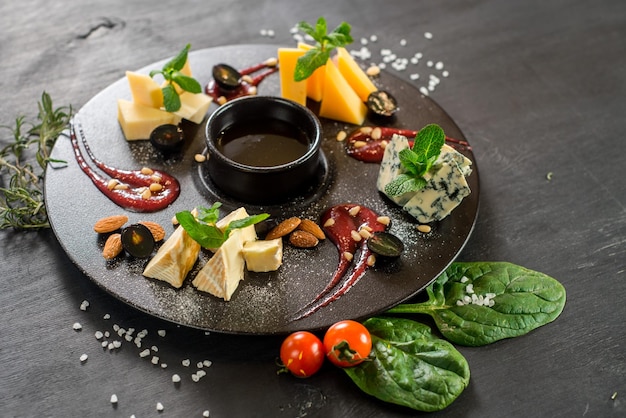 Grande assiette avec assortiment de fromages sur fond de bois